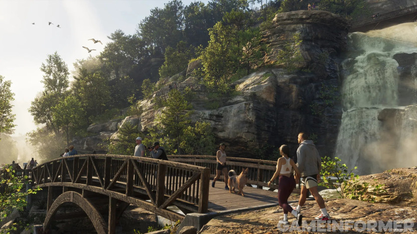 Ein Wasserfall im Mount Kalaga National Park mit einer hölzernen Fußgängerbrücke, Wanderern, einem Jogger mit Hund und Vögeln am Himmel